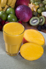 Fototapeta premium Fresh mango juice with fruit in the background