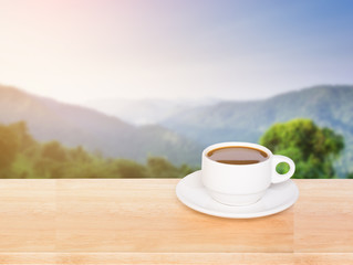 Cup with coffee on table and landscape