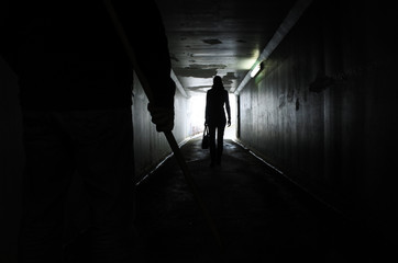 Man follows a young woman in a dark tunnel