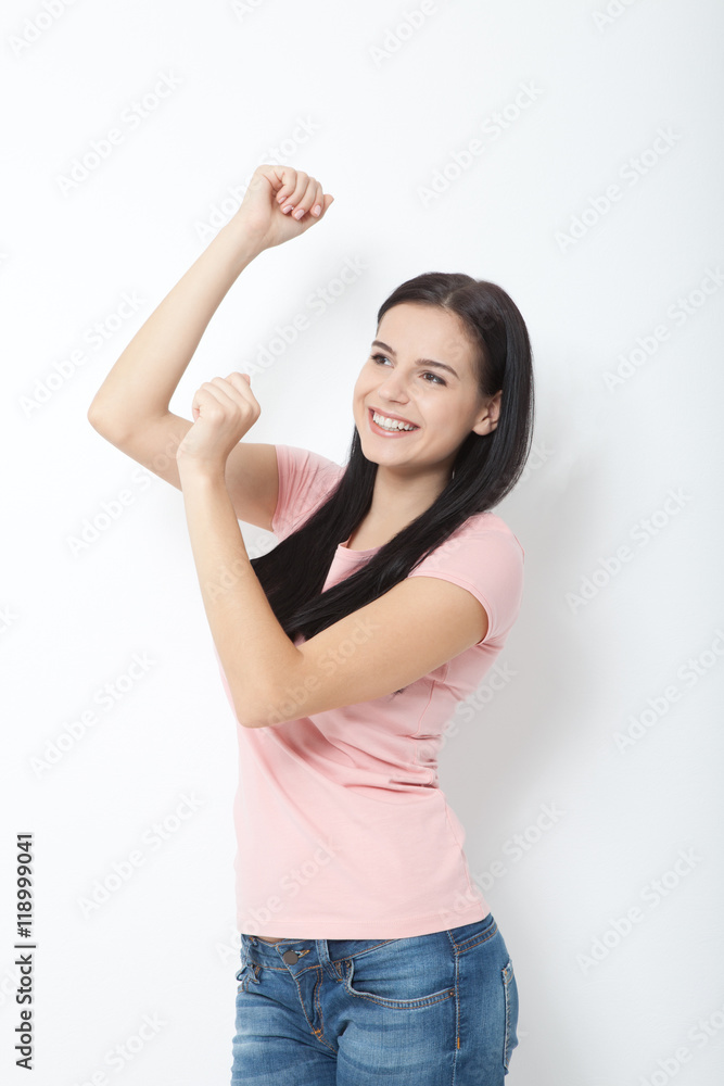 Wall mural portrait of happy young woman dancing on white background