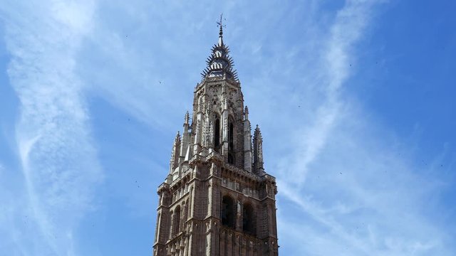 The holy church cathedral at Toledo, Spain, with flock of swallows flying around bell tower