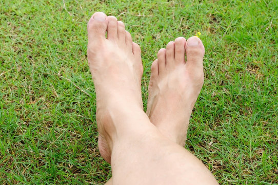 Man legs relaxation on green grass