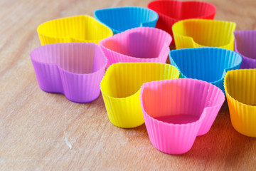 Colorful silicon forms for muffins on the wooden background