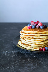 Pancakes on a plate topped with berries, copy space for recipe or text