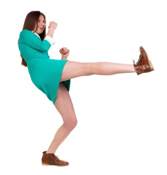skinny woman funny fights waving his arms and legs. Long-haired brunette in a green dress fights feet.