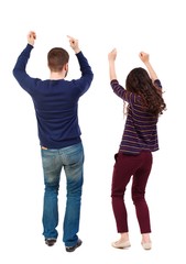 Fototapeta premium Back view of dancing young couple(men and women). Swarthy girl and a bearded man celebrating their victory.
