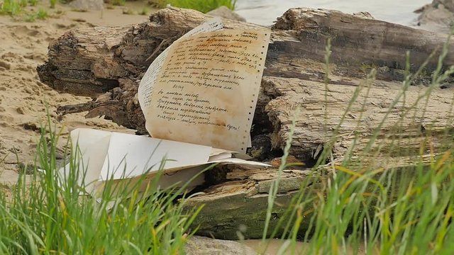Hand-Written Paper Falls Down at the Stone Novelette by Alexander Kuprin Olesya Cyrillic Letters Manuskript Rocky Shore Green Grass Daytime Outdoors