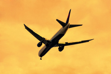 Airplane landing at sunset