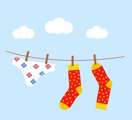 underwear and socks drying on the clothesline against a beautiful blue sky backdrop