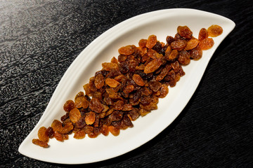 Dried grapes on a white porcelain plate