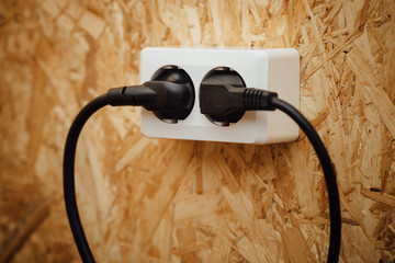 AC power plug and socket, wooden osb wall background