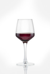glass with red wine on a white background.
