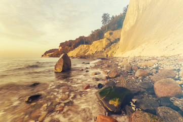 Sea landscape at sunset, sandy beach and cliff,retro colors, vintage