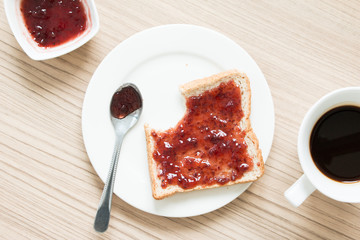 Bitten bread with strawberry jam