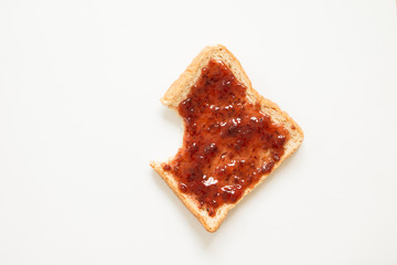 Bitten bread with strawberry jam