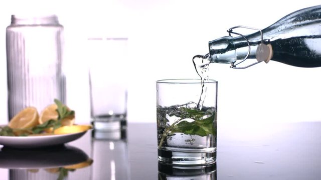 Slow motion shot of mint water being poured