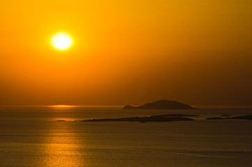 Sunset at sea, with small greek islands in background, Sithonia, Greece