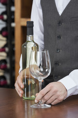 Bartender With White Wine And Glass At Counter