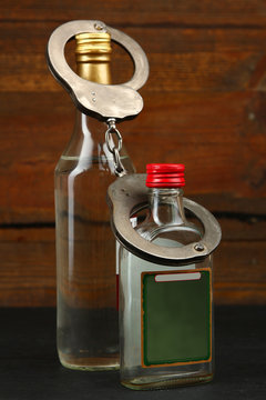 Bottles with alcohol drink on a wooden background. The concept of alcoholism