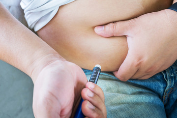 Male diabetes patient injecting insulin in his abdomen area