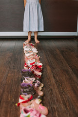 Old worn baby (child, kid) shoes on the floor. sandals, boots, s