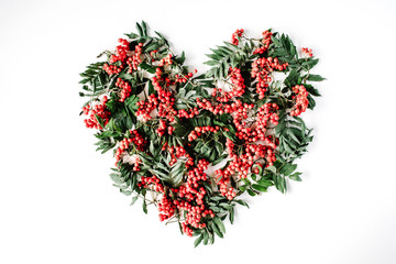 Heart symbol made of rowan on white background. flat lay, top view. autumn wallpaper