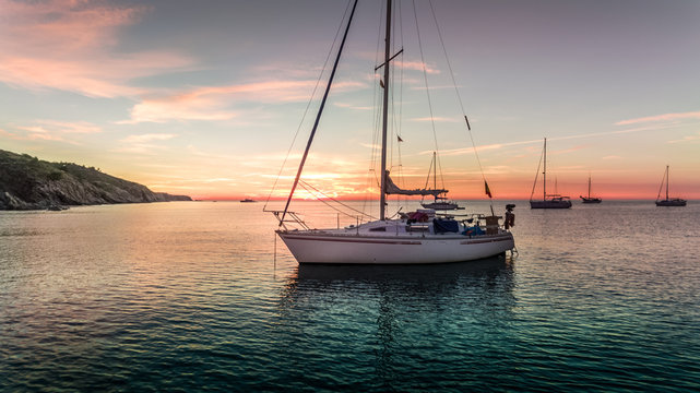 bateau &agrave; voile dans une crique au lev&eacute; du soleil