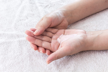 Beautiful female hands applying hand cream