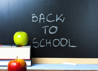 Redand green  apple in front of blackboard with the text 