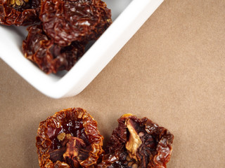 Dried tomatoes on brown background