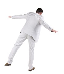 Balancing  businessman  . Rear view. Isolated over white background 