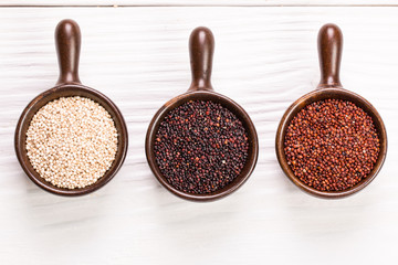 Red, black and white quinoa seeds on a wooden background,healthy food.
