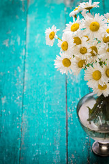 beautiful bouquet of chamomile on vintage wooden table