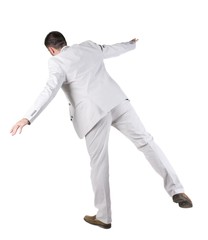 Balancing  businessman  . Rear view. Isolated over white background 