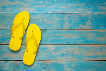 Flip-flop, Sandal, Summer. Yellow flip flop sandals on blue wood - obrazy, fototapety, plakaty