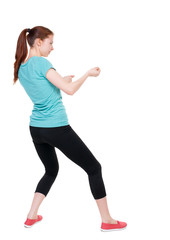 back view of standing woman pulling a rope from the top or cling to something.  Rear view people collection.  backside view of person.  Isolated over white background. Sport girl in black tights