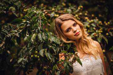 Dark green leaves suround tender face of thoughtful young woman