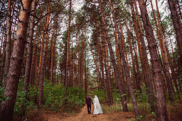 Bride and groom hold their hands together while walking through