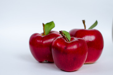 Ripe red apples on a gray background