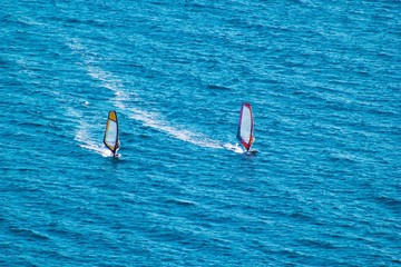 Surfers on blue sea