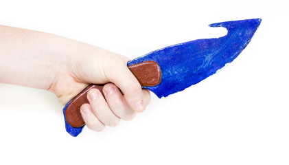 Childrens hand holds wooden model of a knife