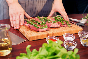 Fresh raw beef meat. Men seasons meat with oil, herbs and spice