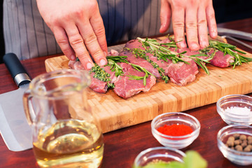 Fresh raw beef meat. Men seasons meat with oil, herbs and spice