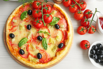 Delicious pizza on wooden cutting board