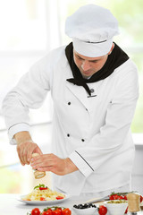Chef preparing delicious pasta in kitchen