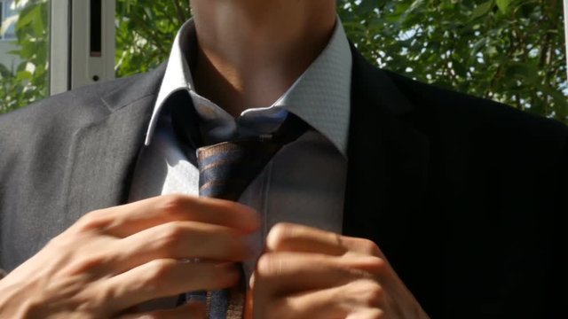 The guy puts on a tie