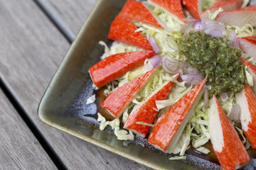 Closeup spicy crab stick salad with fresh cabbage