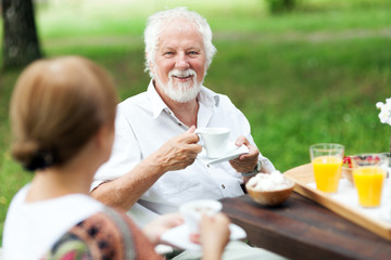 Senior couple enjoying cup of coffee outdoors