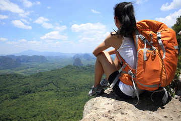 young woman hiker enjoy the view on mountain peak cliff