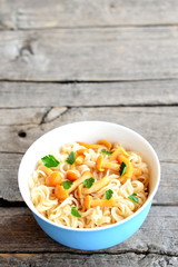 Pasta with mushrooms and fresh herbs recipe. Pasta with marinated chanterelles in a bowl isolated on old wooden background. Vegetarian dish. Closeup